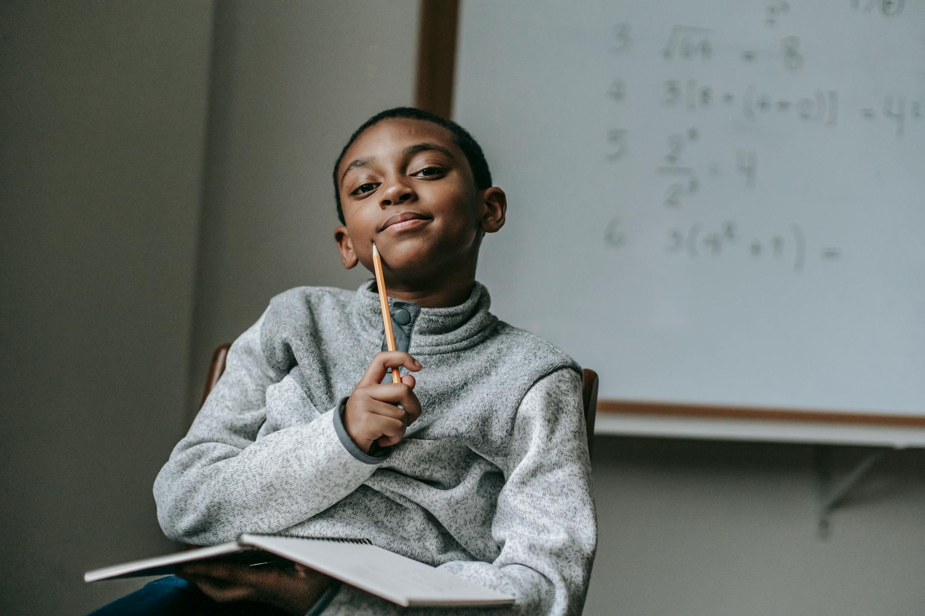 thoughtful black boy with pencil