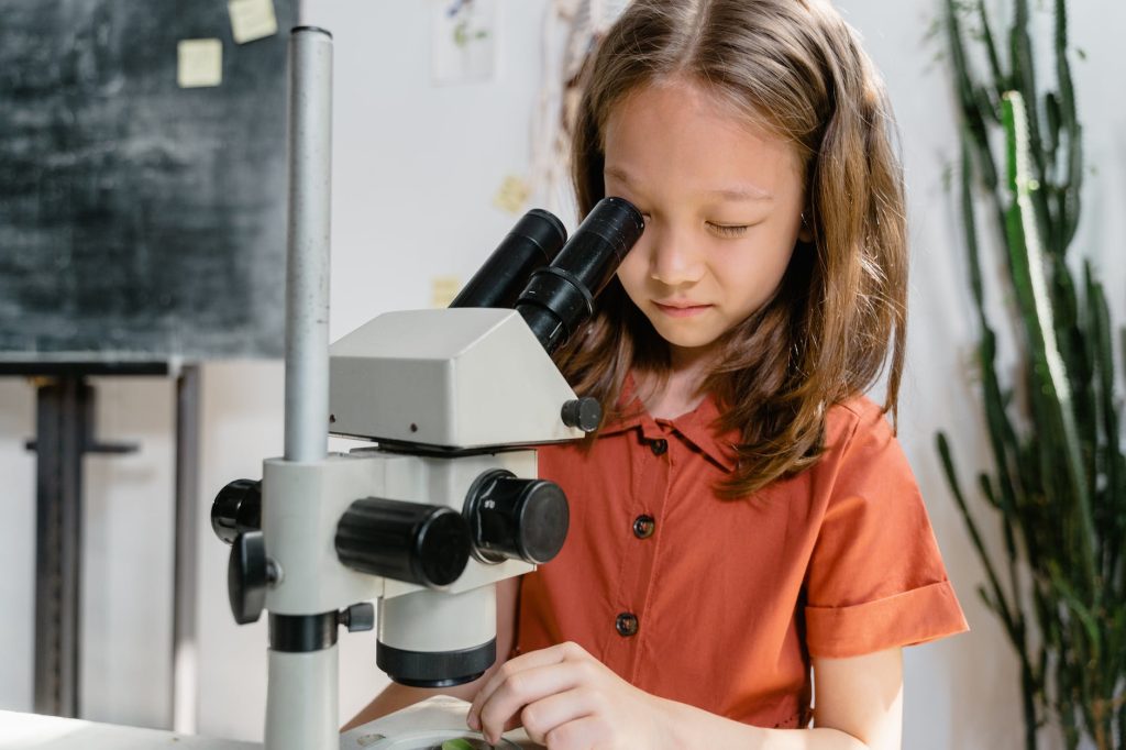 a child looking into a microscope