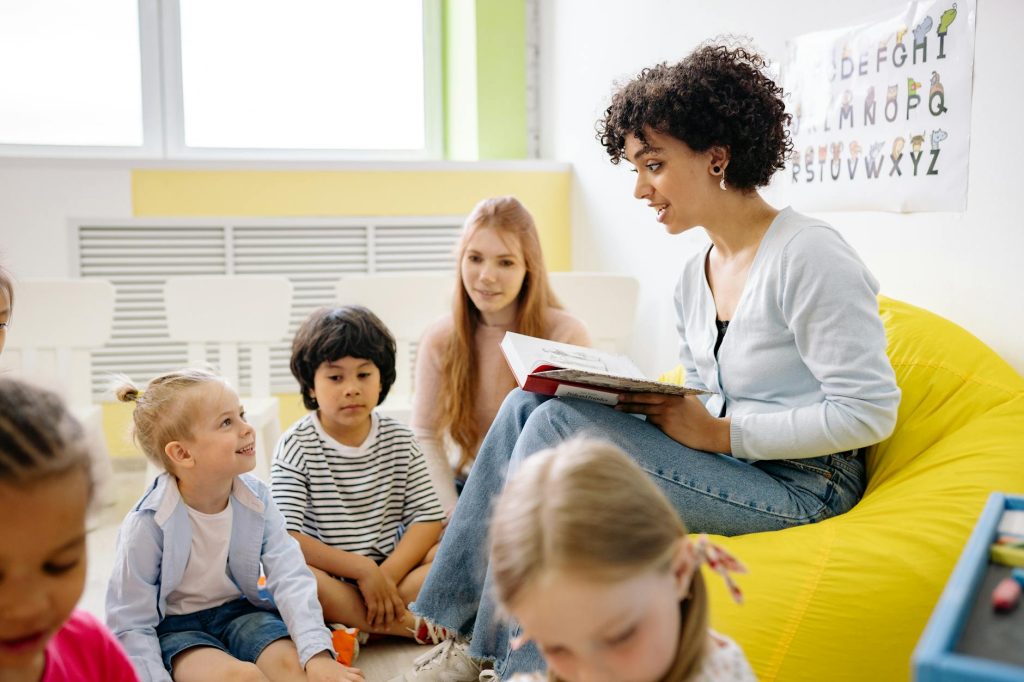 a teacher reading a book to a group of children