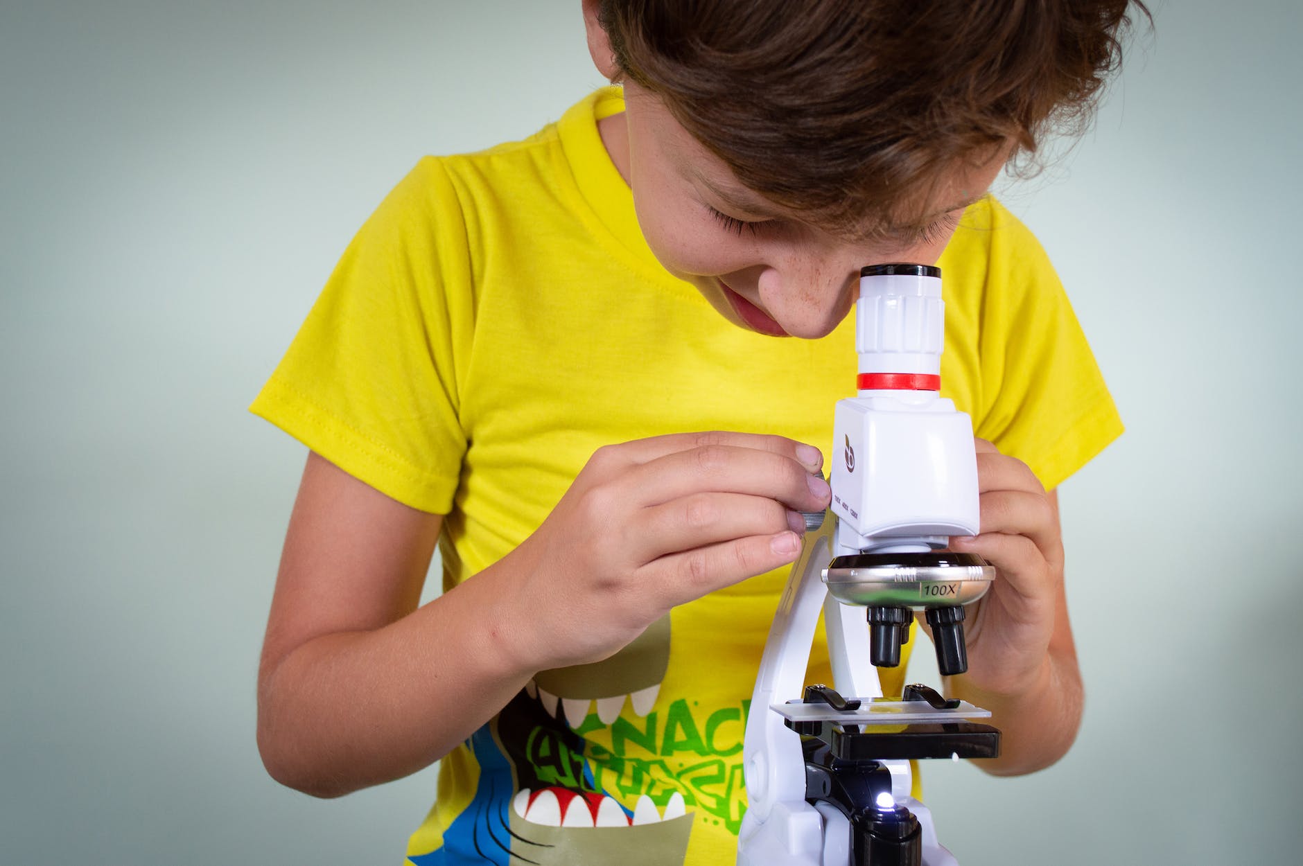 boy looking into a microscope