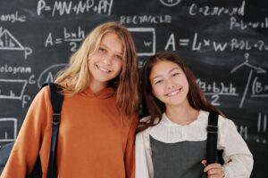 girls posing in front of a blackboard